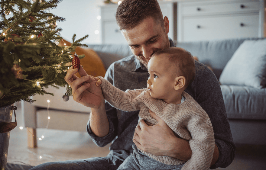 Baby met vader kerstboom versieren